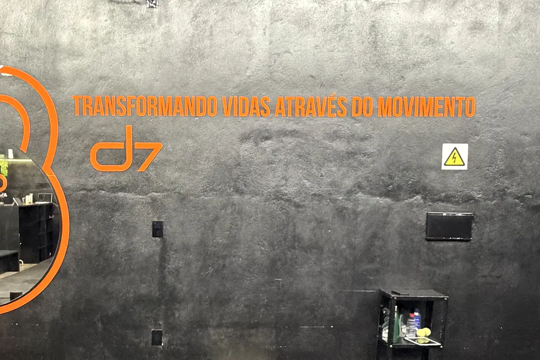 Parede do CT D7 com o lema Transformando vidas através do movimento e o logo d7