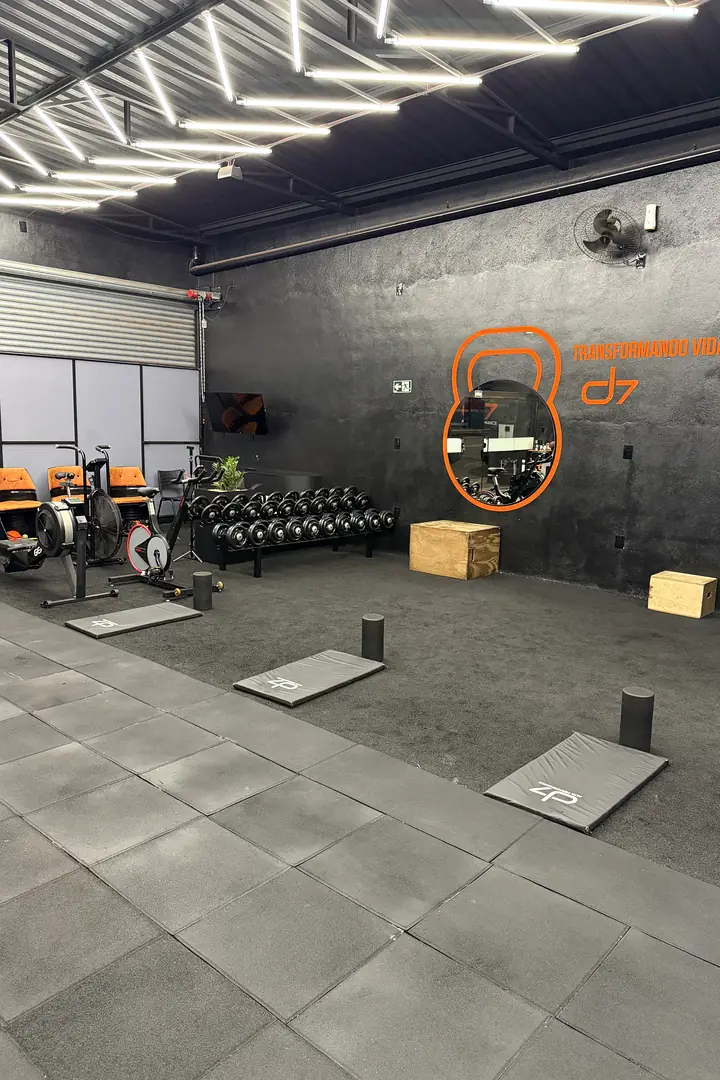 Área funcional do CT D7 com bikes, halteres, caixas de salto e mural de kettlebell