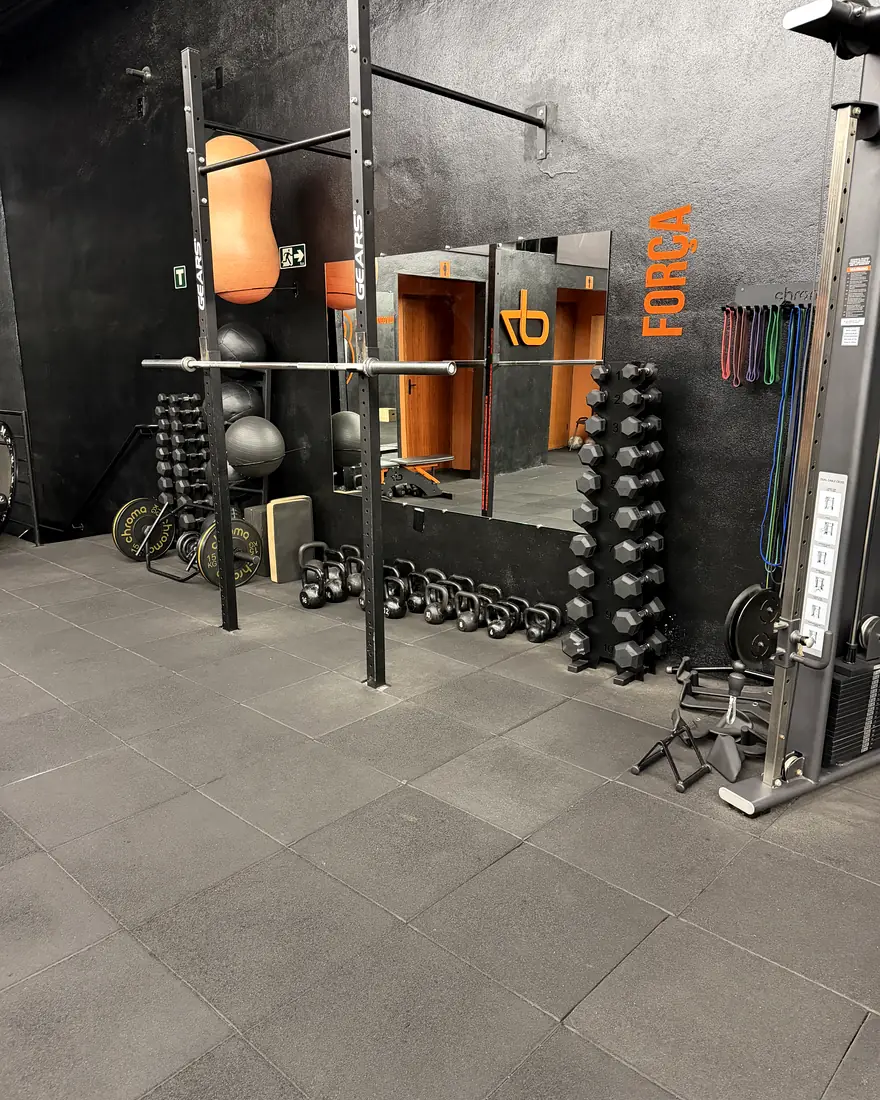 Rack de força, halteres e kettlebells ao lado da parede Força